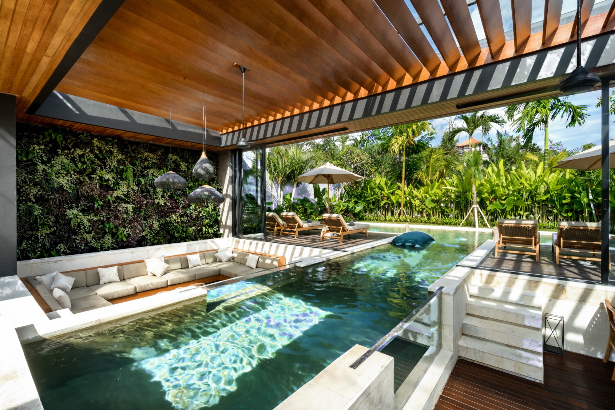 Salon de la Villa Beltza avec piscine intégrée, mur végétal et luminaires en rotin — Pengosekan, Ubud, Bali
